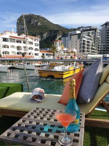 una mesa con una bebida, una botella y un vaso en JASMINE CORAL JAY Boutique Boatel Ocean Village, en Gibraltar