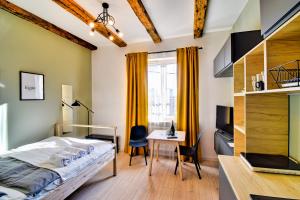 - une chambre avec un lit, un bureau et une table dans l'établissement City Life Apartments Kraków, à Cracovie
