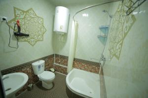 a bathroom with a shower and a toilet and a sink at Fayz Guest House in Khiva