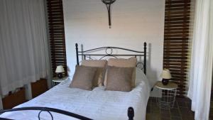 um quarto com uma cama com lençóis brancos e almofadas em Sole e Ventu 90qm em San-Giovanni-di-Moriani