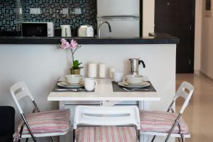 a kitchen with a table with two chairs and a sink at HiGuests - Studio With Incredible Sea Views, 3-min to Beach in Dubai
