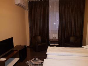 クラヨーヴァにあるVila Crinulのベッド、デスク、椅子が備わるホテルルームです。