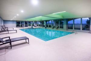 a large swimming pool in a building with windows at La Quinta by Wyndham Lubbock North in Lubbock