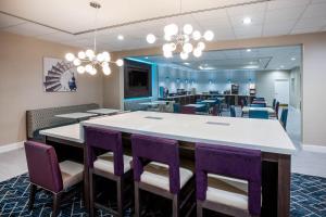 a dining room with a large table and purple chairs at La Quinta by Wyndham Lubbock North in Lubbock +30 photos