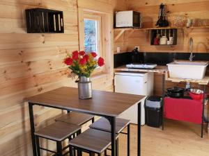 una cocina con una mesa con un jarrón de flores. en La cabane des Pachous en Tourves
