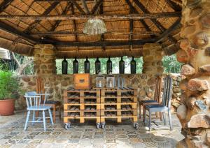 a room with a bunch of wine bottles and chairs at Bridgewaters Horse Park Tranquil Country Cottage in Hekpoort