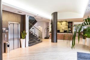 eine Lobby mit Topfpflanzen und einer Treppe in der Unterkunft Clement Barajas in Madrid