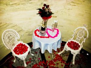 a table with a vase of flowers and two chairs at Zamek Pod Brzozami, Wynajem Pokoi in Krynica Zdrój