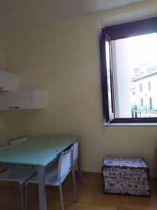 利維松多里的住宿－FORT. Montagna A305，客房设有桌子、两把椅子和窗户。