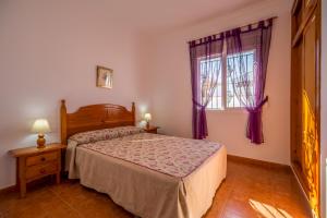 een slaapkamer met een bed en een raam bij Chalet Pedro I in Conil de la Frontera