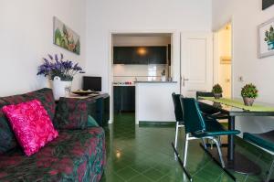 ein Wohnzimmer mit einem Sofa und einem Tisch sowie eine Küche in der Unterkunft Casa Vacanza Kair Trilo 263 in Sperlonga