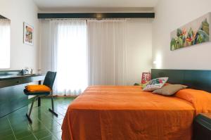 een slaapkamer met een groot bed en een oranje deken bij Casa Vacanza Kair Trilo 227 in Sperlonga
