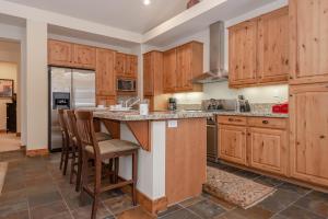 a kitchen with wooden cabinets and a island with bar stools at Lodges 1140 in Old Mammoth
