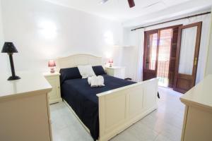 a bedroom with a large bed with a blue blanket at Casa típica Mallorquina con mucho encanto in Santanyi