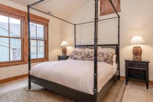 a bedroom with a four poster bed and two lamps at Lodges 1140 in Old Mammoth