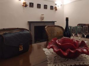 uma mesa com uma garrafa de vinho e uma flor vermelha em FORT Montagna Casa Impero CIR 06678CVP0002 em Rivisondoli