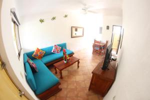 a living room with a blue couch and a television at Hotel Casa Iguana Mismaloya in Puerto Vallarta