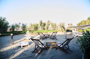 a group of chairs and a table in the sand at Hotel Enterprise in Montalto di Castro