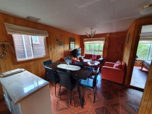 a kitchen and living room with a table and chairs at Cabañas JP Licanray in Licán Ray