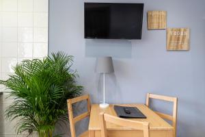 a table with two chairs and a television on a wall at Spacious Apartment in King's Cross St Pancras in London