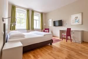 um quarto com uma cama, uma secretária e uma cadeira em Boutique Hotel SwissHouse em Mariánské Lázně