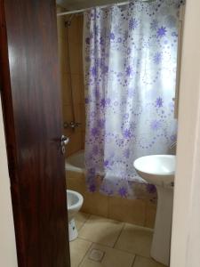 uma casa de banho com um lavatório, um WC e uma cortina de chuveiro. em Departamento Naranja em Tandil