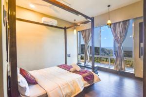 1 dormitorio con cama y ventana grande en Meraki Villa en Panchgani