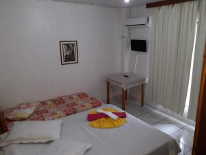 - une chambre avec un lit, une table et une télévision dans l'établissement HOTEL PINOTTI LTDA, à Curitibanos