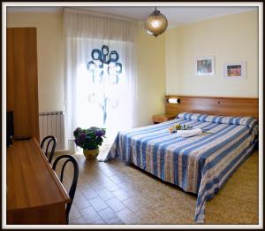 a bedroom with a bed and a table and a window at Hotel Del Golfo in Lerici