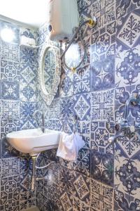 baño con lavabo y azulejos azules y blancos en Homestay Siolim, en Siolim