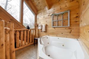 a large white tub in a room with wooden walls at Once Upon a Time by Venture Smoky Mountains in Sevierville +49 photos