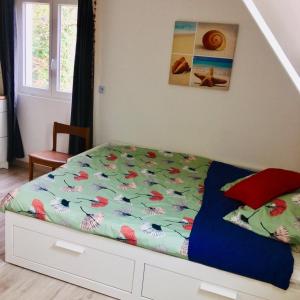 a bedroom with a bed with a colorful bedspread at Refuge des voyageurs in Plouédern