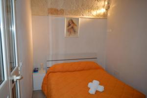 - une chambre dotée d'un lit orange avec un ours en peluche dans l'établissement A due passi dal mare locazione turistica, à Polignano a Mare