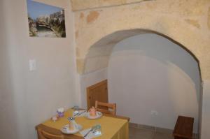 une salle à manger avec une table et une voûte dans l'établissement A due passi dal mare locazione turistica, à Polignano a Mare