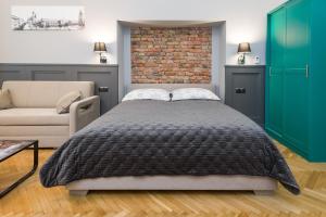 a bedroom with a bed and a brick wall at LUXURY Apartment at the Main Square Tomasza street in Krakow