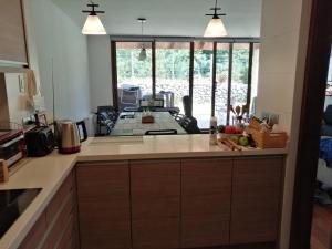 a kitchen with a counter top and a large window at Parque Pinares-Maravilloso-Playa -Muelle-Bosque in Pucón