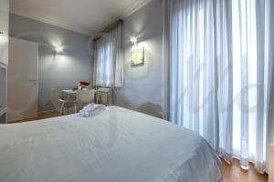a bedroom with a large white bed and a desk at Ripetta 25 Prestige Rooms in Rome