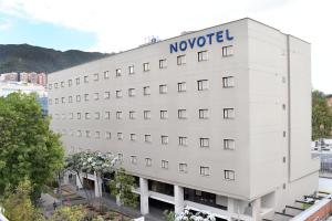 un bâtiment blanc avec le panneau novotel sur celui-ci dans l'établissement Novotel Bogota Parque 93, à Bogotá