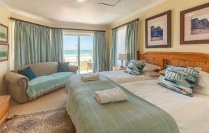 una camera da letto con due letti, un divano e una finestra di Lyngenfjord House a Cape St Francis