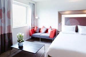 a hotel room with a bed and a couch at Novotel London Waterloo in London