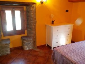 1 dormitorio con cama, ventana y vestidor en Ca L'Estrada, en Sant Esteve de Palautordera