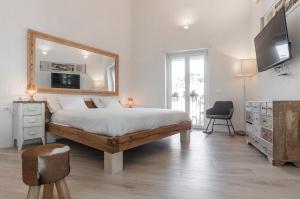 1 dormitorio con 1 cama con espejo y silla en New Luxus Apartment in Gaeta with sea view on harbour, en Gaeta