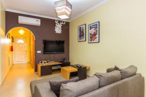 ein Wohnzimmer mit einem Sofa und einem TV in der Unterkunft Villa Engiadina by ALGARVEMANTA in Manta Rota