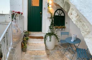 a green door on a white house with a table at Panta Rei in Ostuni