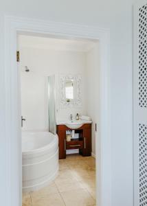 uma casa de banho branca com uma banheira e um lavatório em Eden View Cottage, Sheffield Beach em Sheffield Beach