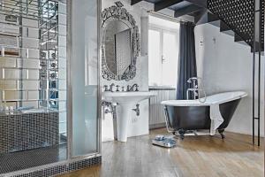 łazienka z wanną, umywalką i lustrem w obiekcie G-Rough, Rome, a Member of Design Hotels w Rzymie