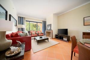 a living room with a red couch and a tv at AL - Apartamentos Vila Sol F5 Bloco 3 in Quarteira