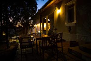 a table and chairs outside of a house at night at Casa de Vacanta Nora in Oveselu
