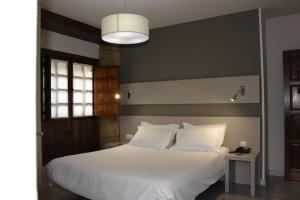 Un dormitorio con una cama grande con sábanas blancas. en Los Guardeses, en Solares