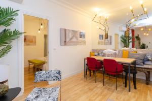 ein Esszimmer und ein Wohnzimmer mit einem Tisch und Stühlen in der Unterkunft Palacio Premium Stay in Madrid
